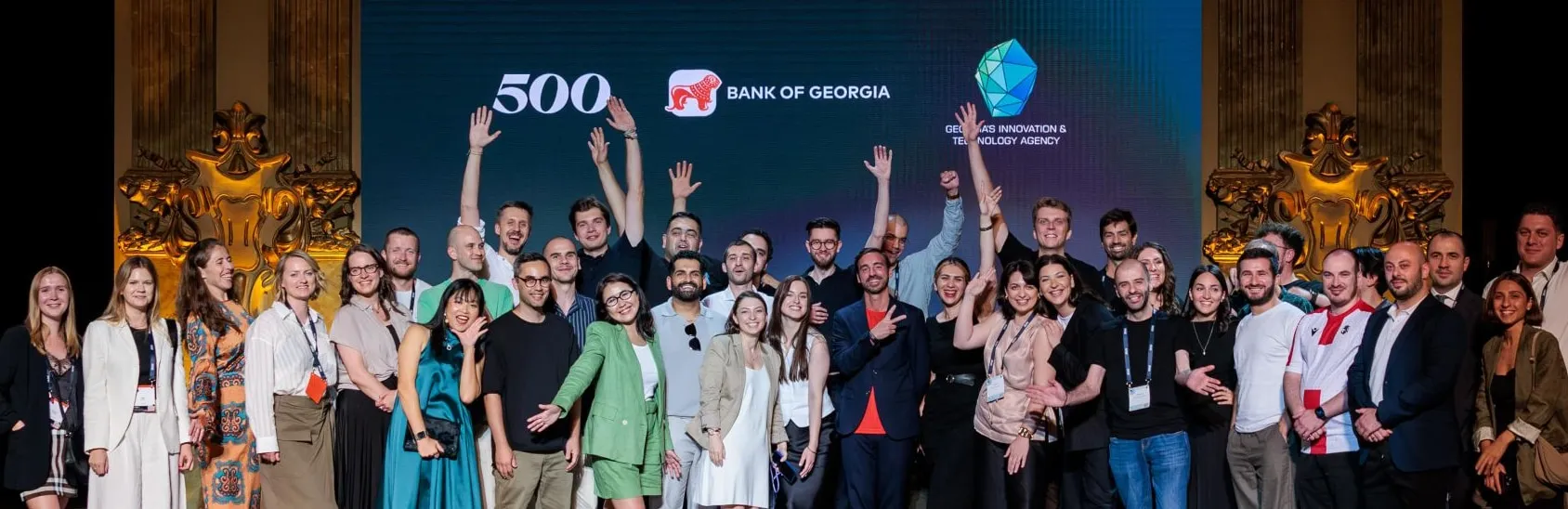 Group photo of founders and mentors on stage at a 500 Global demo day in Georgia